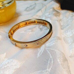 Gold Tone Bangle Bracelet reticulated with clear Rhinestones